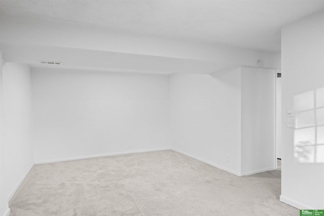 spare room featuring carpet floors and baseboards