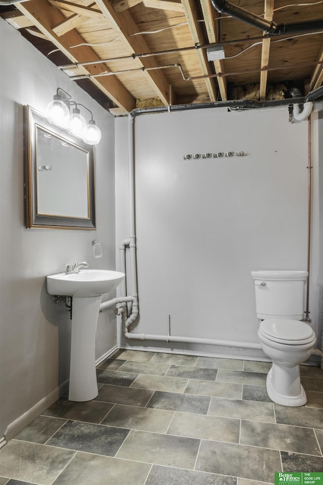 half bathroom featuring baseboards and toilet