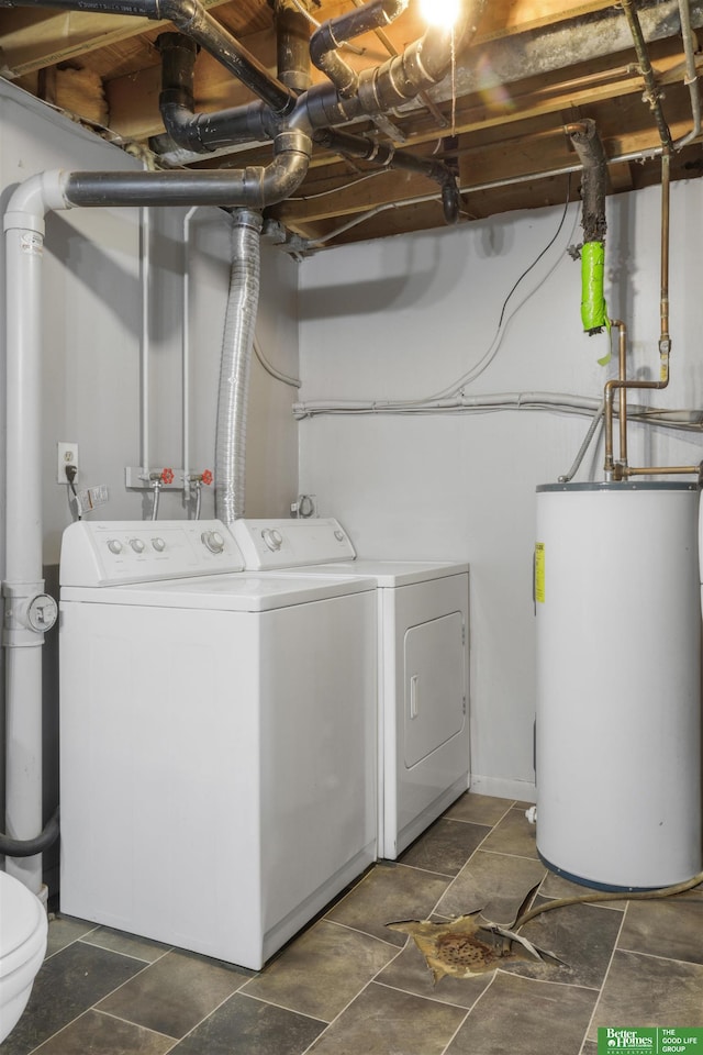 washroom with washing machine and clothes dryer, laundry area, stone finish floor, and gas water heater