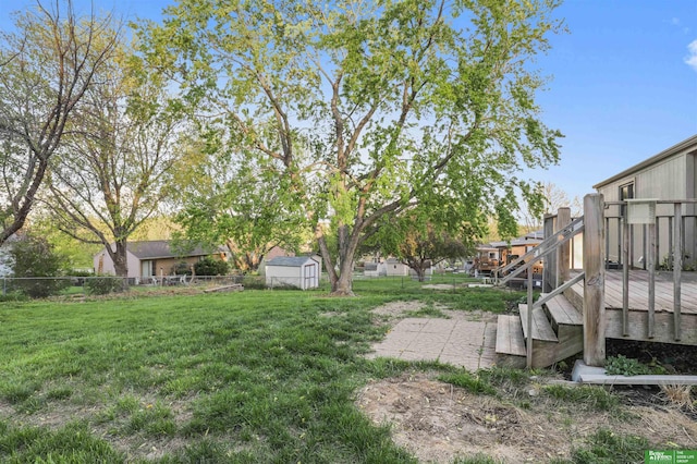 view of yard featuring a fenced backyard, an outbuilding, a storage shed, and a deck