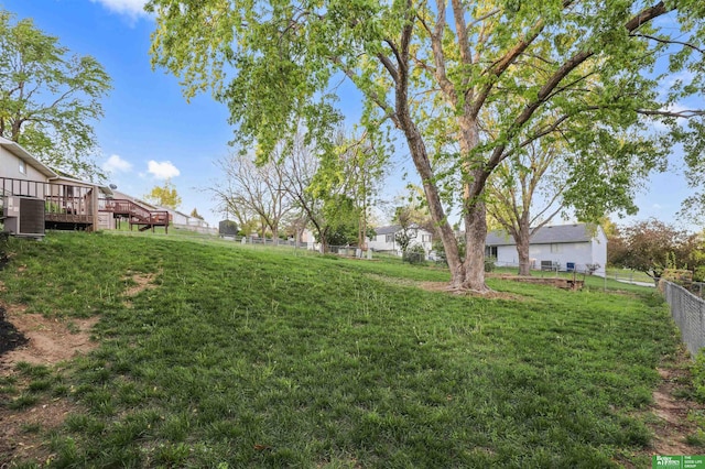 view of yard with central AC, fence, and a wooden deck