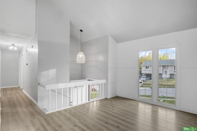 unfurnished room with baseboards, high vaulted ceiling, and wood finished floors