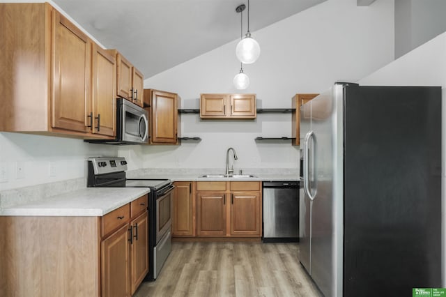 kitchen with appliances with stainless steel finishes, vaulted ceiling, light wood-type flooring, a sink, and light countertops