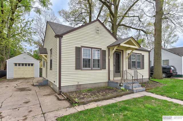 bungalow-style home featuring a front yard, a detached garage, an outdoor structure, concrete driveway, and a shingled roof