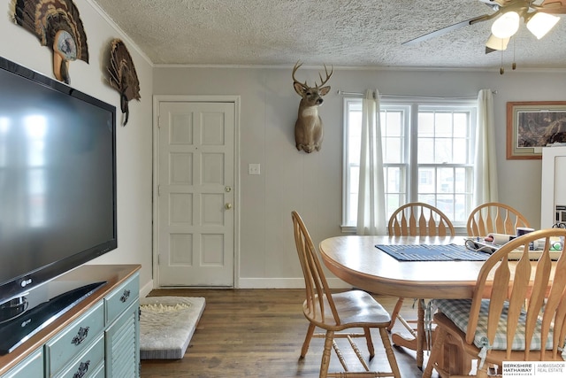dining space with crown molding, baseboards, dark wood-type flooring, a textured ceiling, and a ceiling fan
