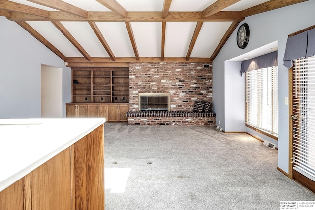 unfurnished living room with carpet floors, lofted ceiling with beams, visible vents, and built in shelves