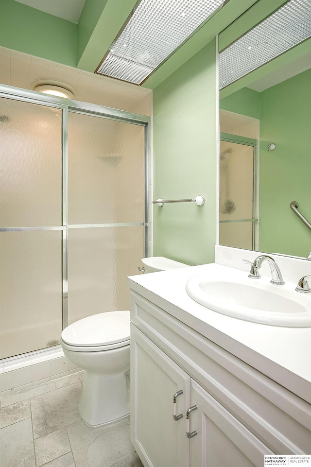 bathroom with vanity, toilet, and a stall shower