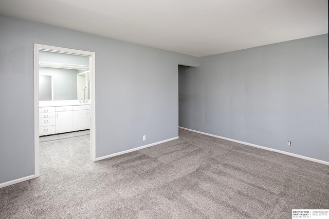 carpeted spare room featuring baseboards