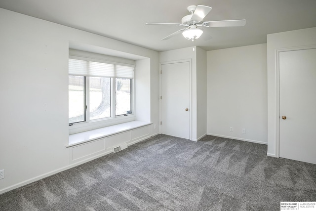 unfurnished bedroom with visible vents, a ceiling fan, baseboards, and dark carpet