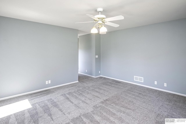 carpeted empty room with baseboards, a ceiling fan, and visible vents