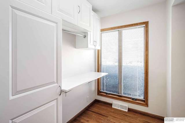 mudroom with dark wood-style flooring, baseboards, and visible vents