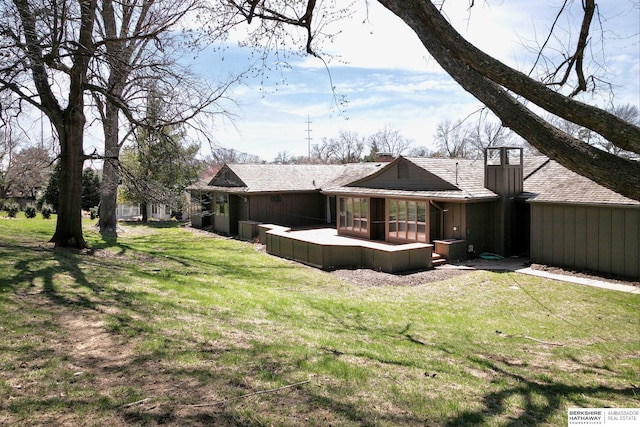 back of property with a yard and a chimney