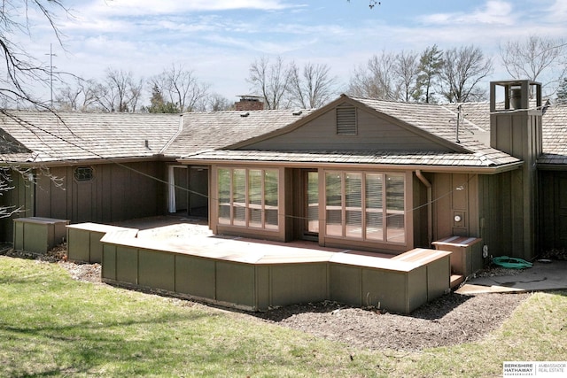back of property featuring a yard and a chimney