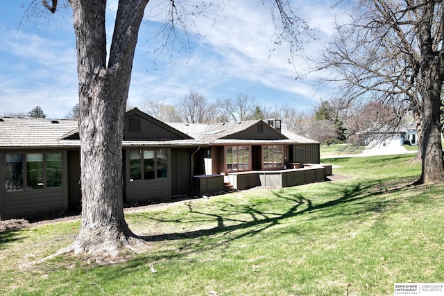 back of house featuring a lawn and board and batten siding