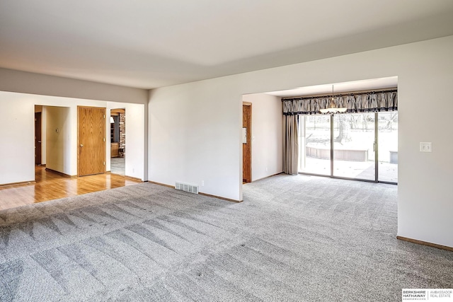 empty room with visible vents, carpet, and baseboards