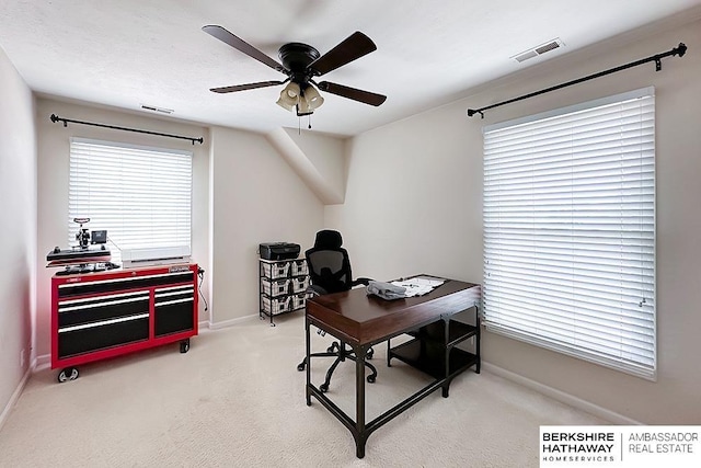 carpeted home office featuring visible vents, baseboards, and ceiling fan