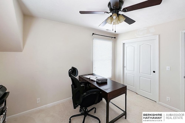 office featuring baseboards, ceiling fan, visible vents, and light carpet