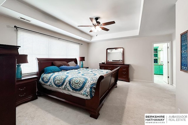 bedroom with visible vents, baseboards, ceiling fan, light colored carpet, and a raised ceiling
