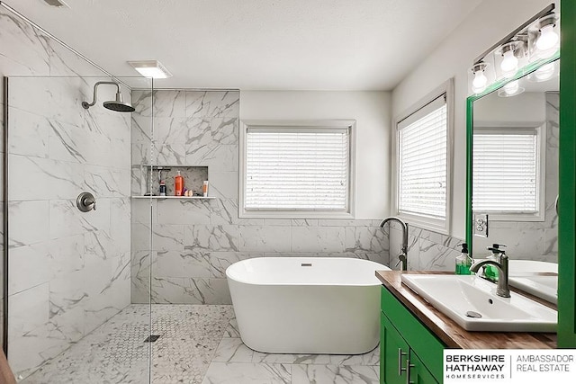 bathroom featuring vanity, marble finish floor, a marble finish shower, and a soaking tub