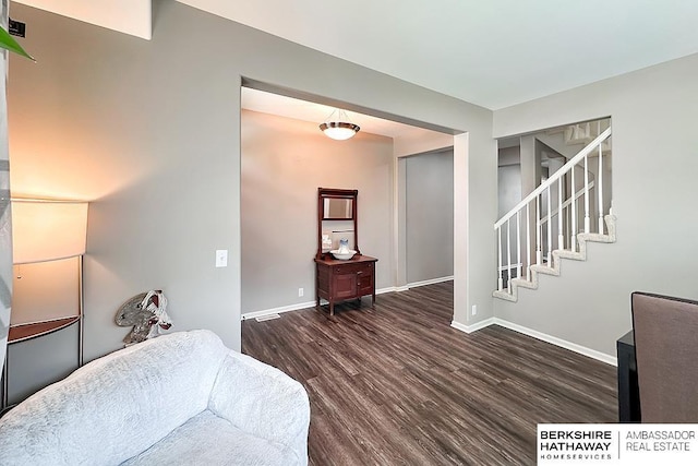 living room featuring stairway, baseboards, and dark wood finished floors