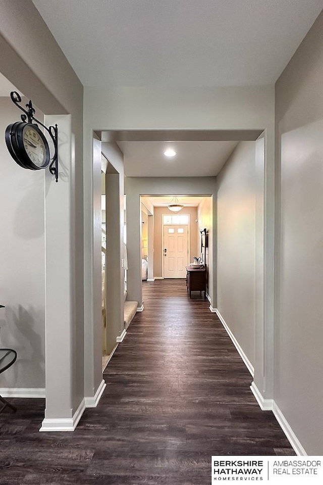 corridor featuring baseboards, recessed lighting, and wood finished floors