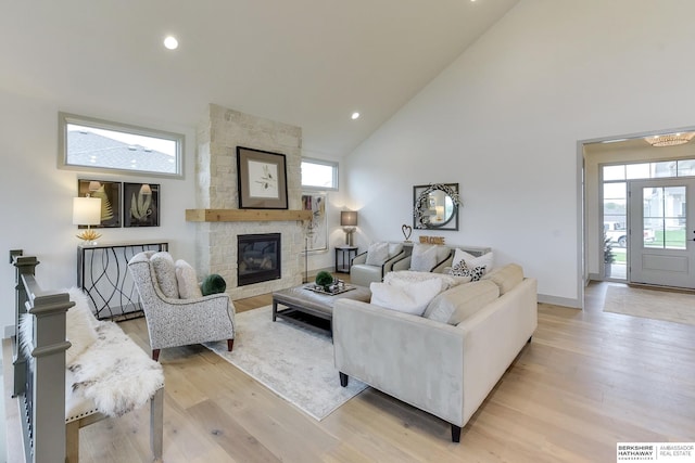 living room with a fireplace, light wood-style floors, high vaulted ceiling, recessed lighting, and visible vents