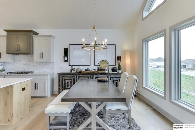 dining room with an inviting chandelier, baseboards, light wood-type flooring, and visible vents