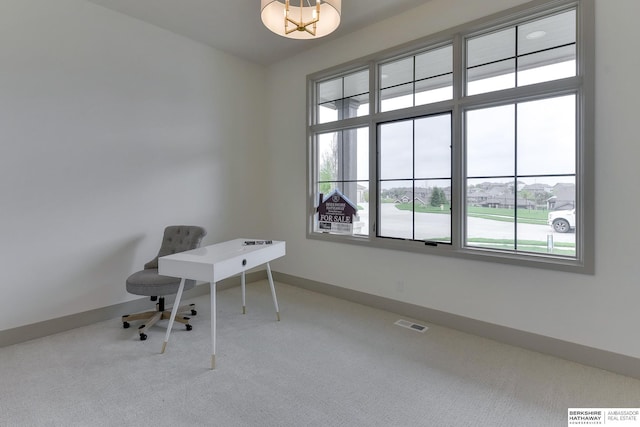 carpeted home office with a healthy amount of sunlight, baseboards, and visible vents