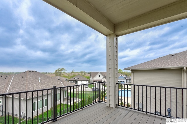 wooden terrace featuring a community pool and a residential view