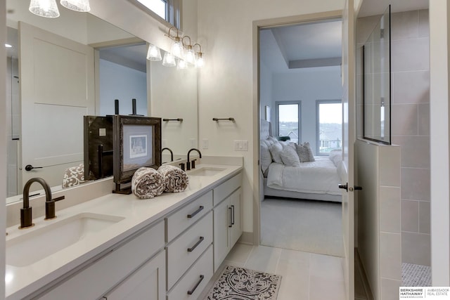 ensuite bathroom featuring a sink, tile patterned floors, ensuite bathroom, and walk in shower