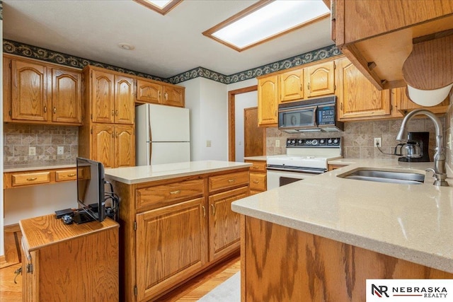 kitchen with decorative backsplash, white appliances, a center island, light countertops, and a sink