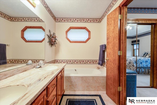 full bath featuring connected bathroom, double vanity, a sink, and a bath