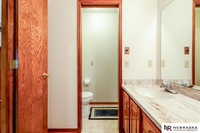 bathroom featuring toilet, baseboards, tile patterned flooring, and vanity