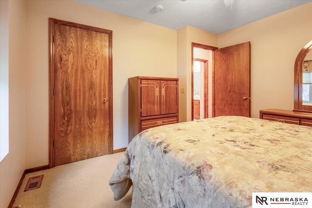 carpeted bedroom featuring visible vents and baseboards