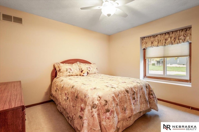 bedroom with a ceiling fan, baseboards, visible vents, and carpet