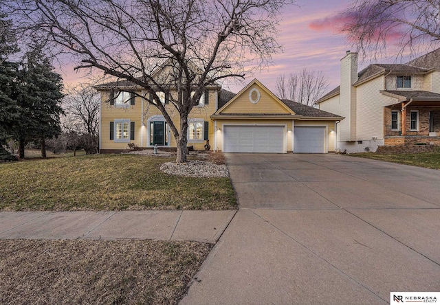 view of front of house featuring a yard, driveway, and a garage