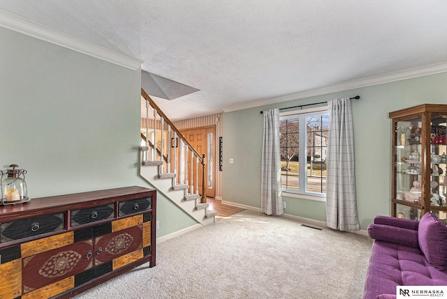 living area featuring crown molding, carpet flooring, visible vents, and stairway
