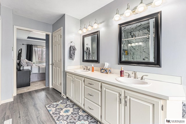 bathroom featuring double vanity, a sink, a marble finish shower, and ensuite bathroom