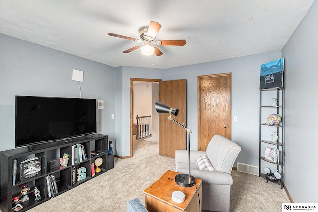living area featuring carpet flooring, ceiling fan, visible vents, and baseboards