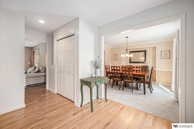dining room with crown molding, baseboards, a chandelier, and wood finished floors