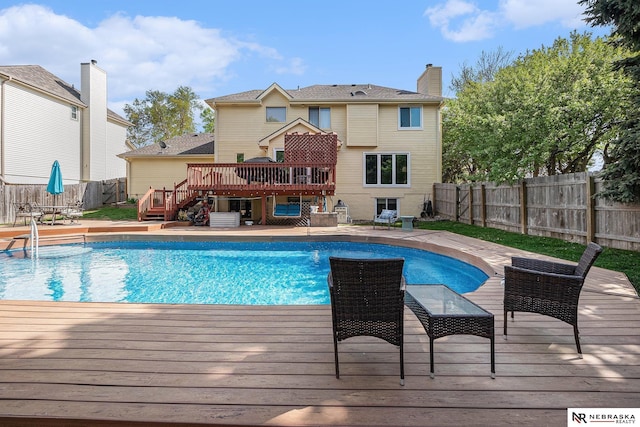 view of swimming pool featuring a fenced in pool, a fenced backyard, a wooden deck, and stairway