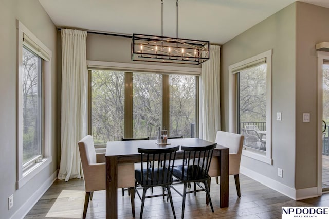 dining room with an inviting chandelier, baseboards, and wood finished floors