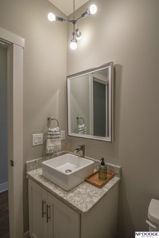 half bath featuring vanity and toilet