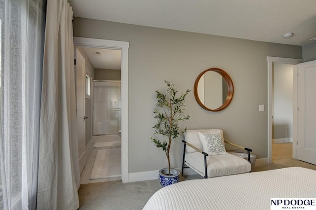bedroom featuring baseboards, light carpet, and ensuite bathroom