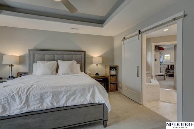 bedroom featuring ceiling fan, visible vents, a barn door, and light carpet