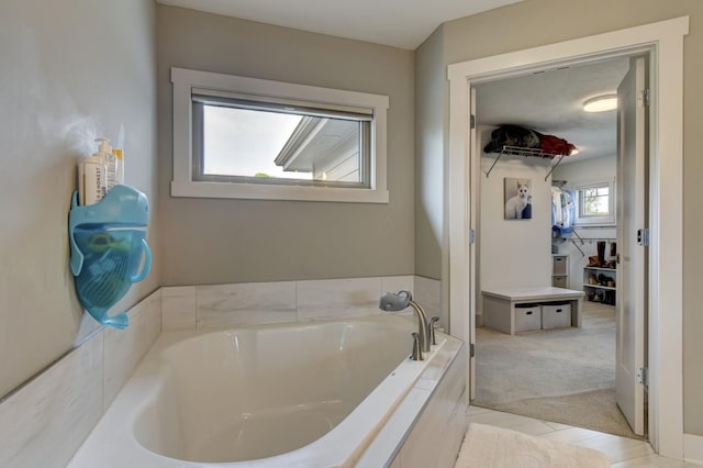 bathroom with a garden tub and tile patterned floors