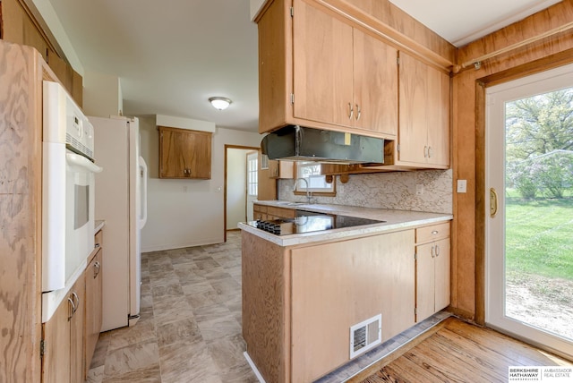 kitchen with visible vents, a peninsula, white appliances, light countertops, and under cabinet range hood