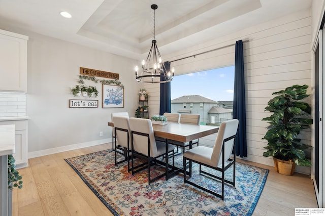 17026 Emma St, Bennington, NE 68007 - dining room with light wood-style floors, baseboards, recessed lighting, a raised ceiling, and a chandelier
