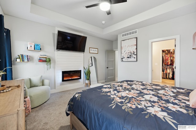 17026 Emma St, Bennington, NE 68007 - carpeted bedroom with visible vents, baseboards, a raised ceiling, a large fireplace, and a ceiling fan