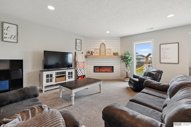 17026 Emma St, Bennington, NE 68007 - carpeted living room featuring a glass covered fireplace, recessed lighting, and visible vents